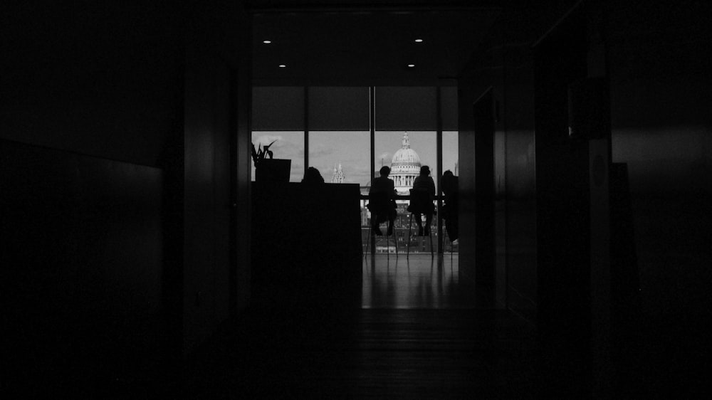 uma foto em preto e branco de pessoas em pé em um corredor
