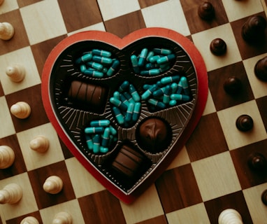 a heart shaped box of chocolates on a chess board