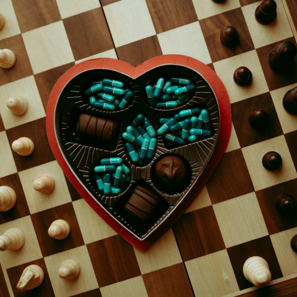 Una caja de chocolates en forma de corazón en un tablero de ajedrez