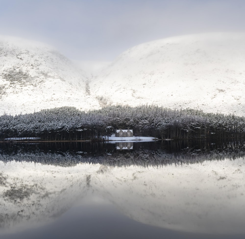 a snow covered mountain with a lake in the foreground