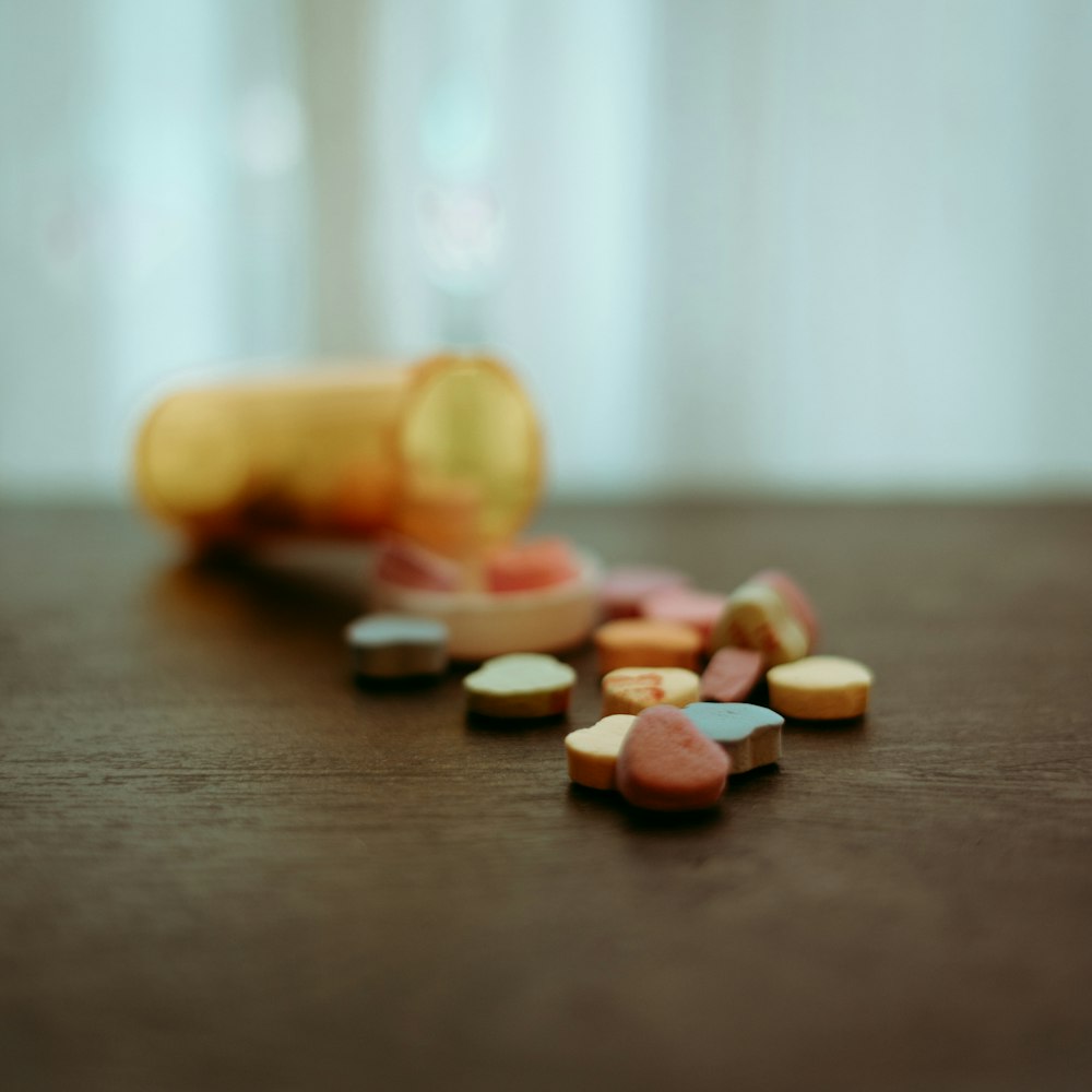 um frasco de pílulas sentado em cima de uma mesa de madeira