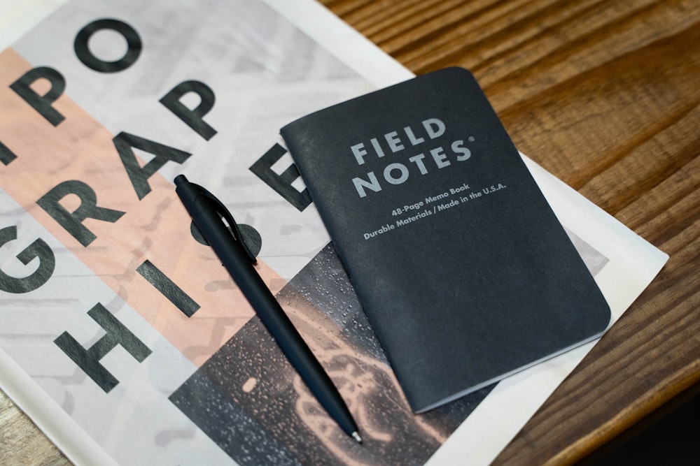 a book and a pen sitting on top of a table