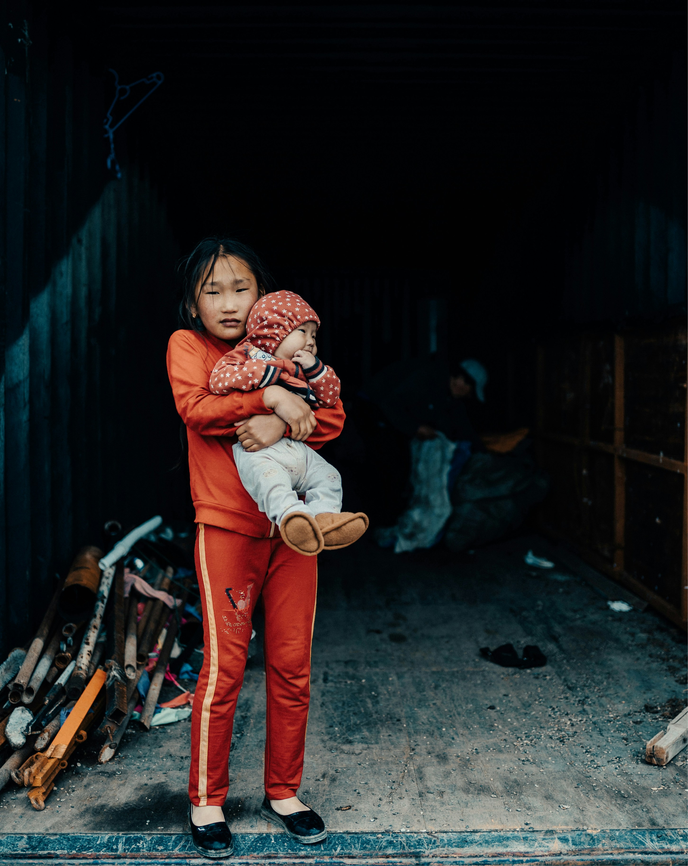 a young girl holding a baby in her arms