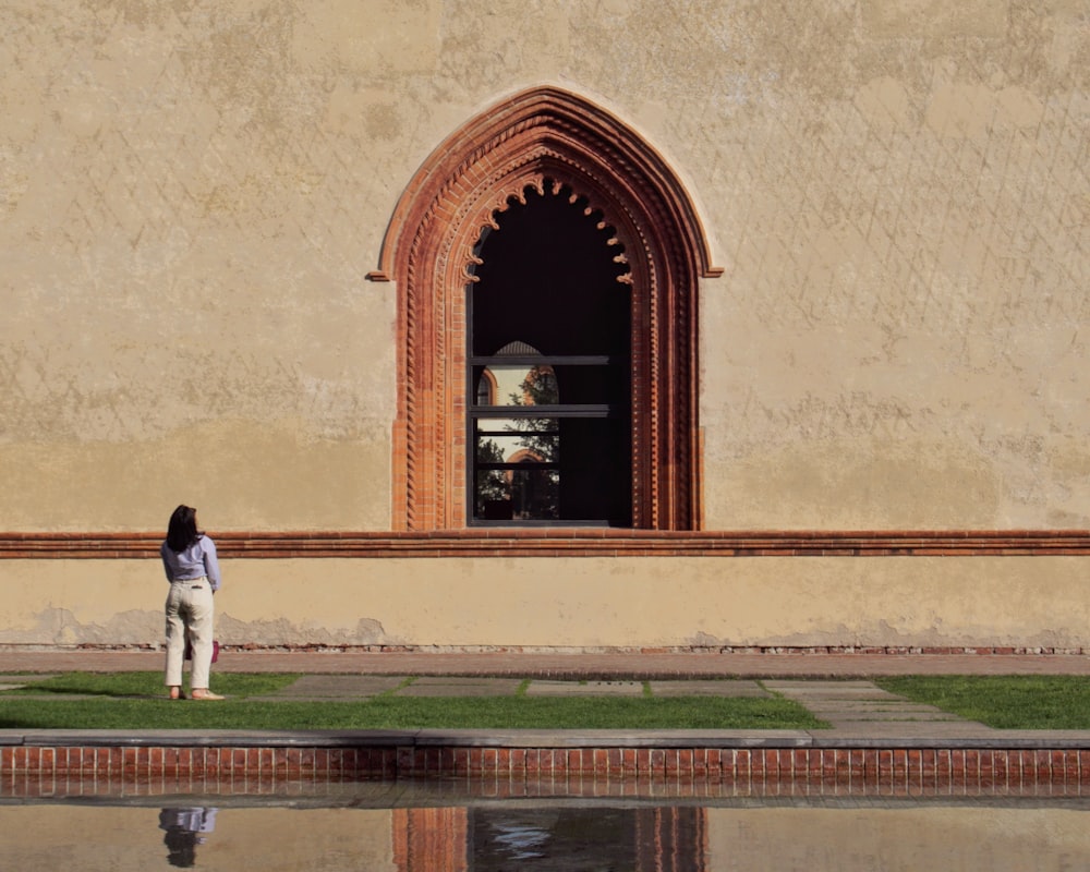 a woman is standing in front of a building