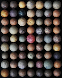 Smooth jasper stones in earthy tones arranged artfully on a dark fabric background.