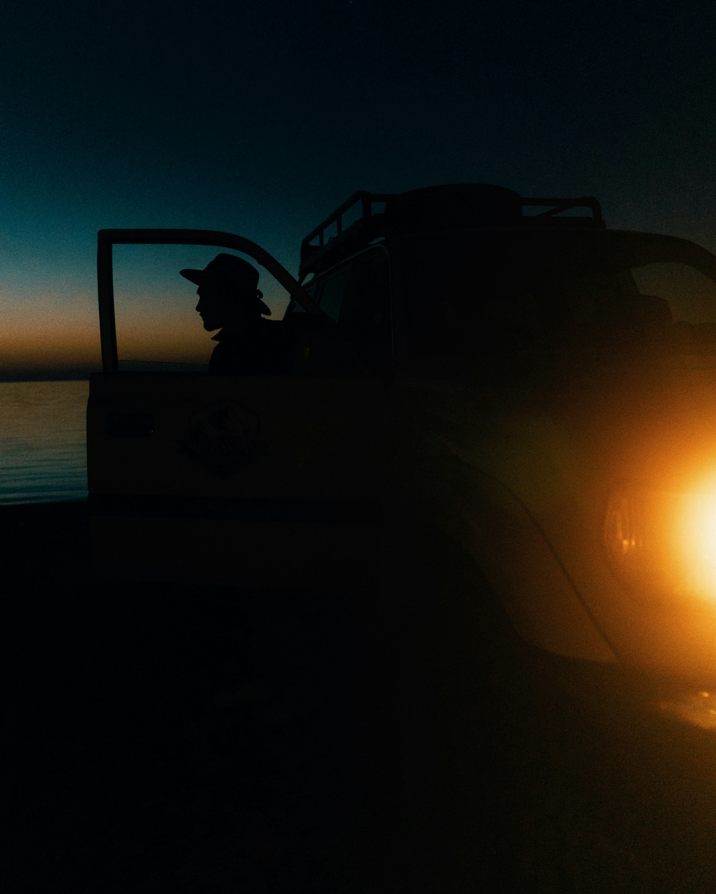a man sitting in the back of a truck at night