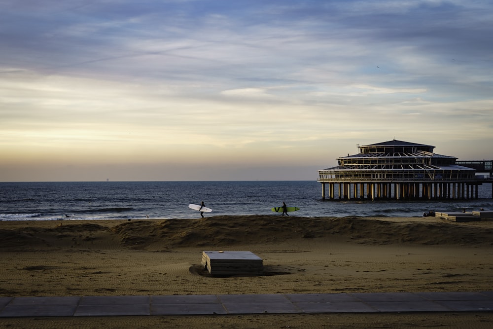 a building sitting on top of a sandy beach next to the ocean