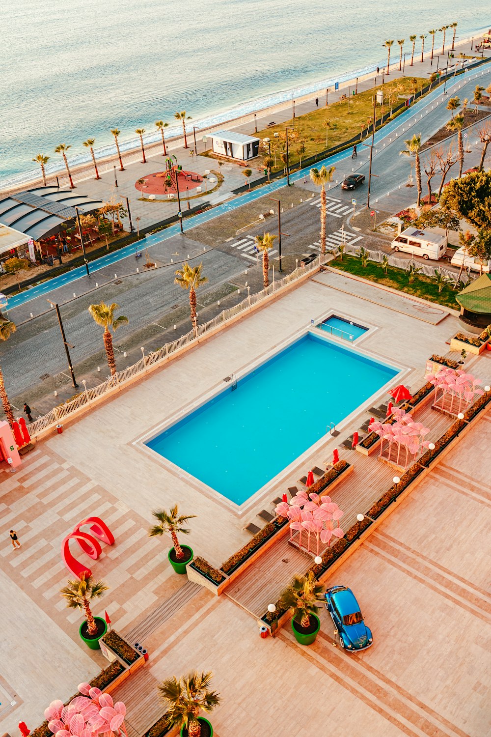 an aerial view of a large swimming pool next to a beach