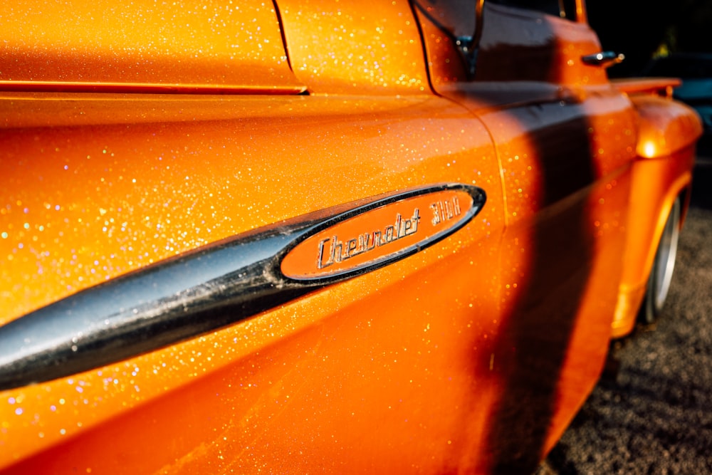 a close up of the emblem on an orange car