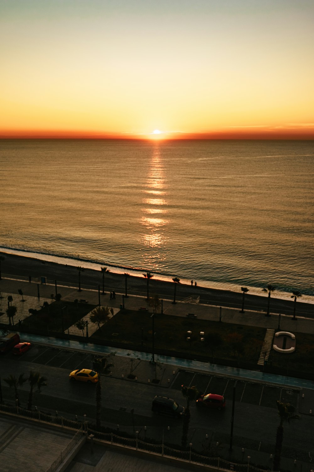 the sun is setting over the ocean from a balcony