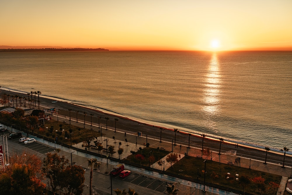 the sun is setting over the beach and ocean