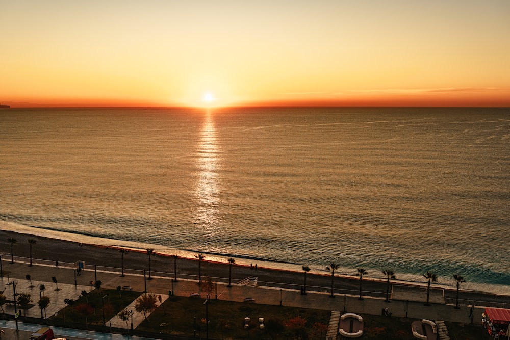 the sun is setting over the ocean and beach