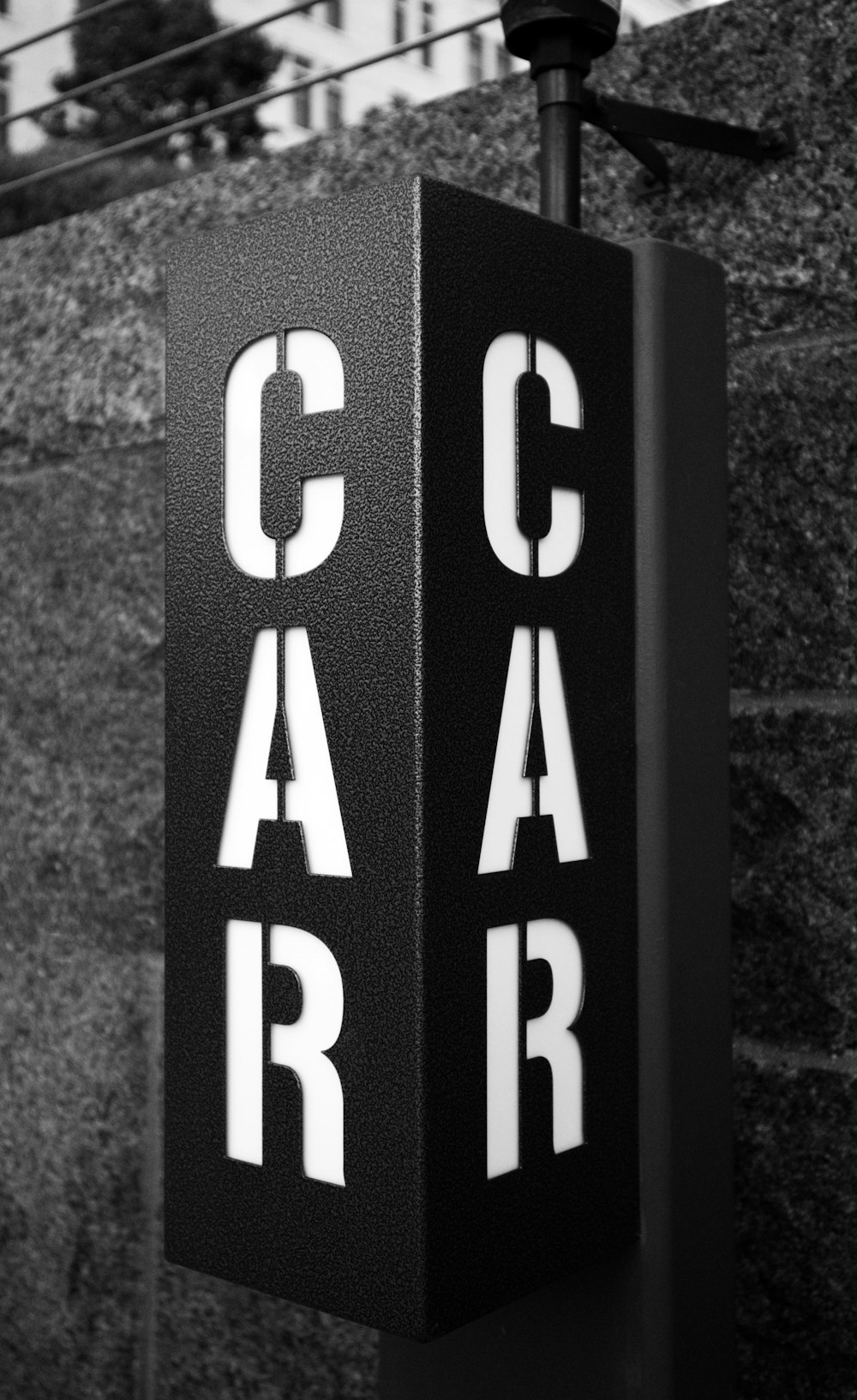 a black and white photo of a car sign