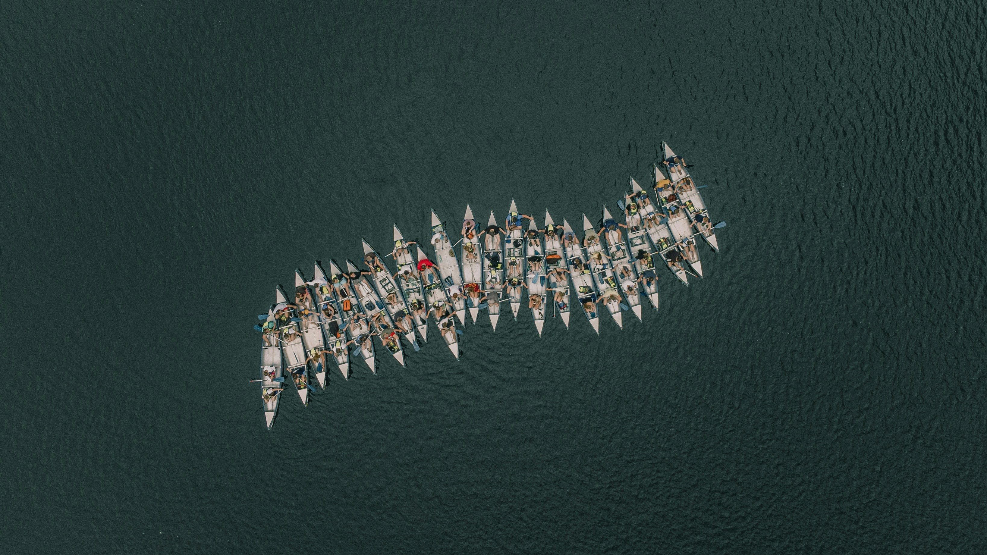 a large group of boats floating on top of a body of water