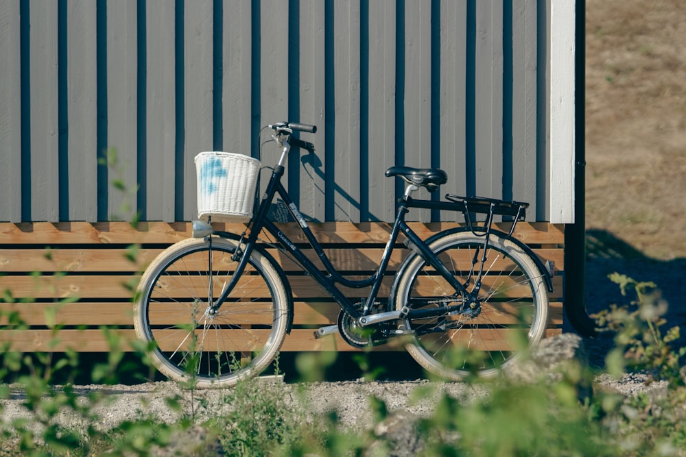 a bicycle parked next to a wooden fence