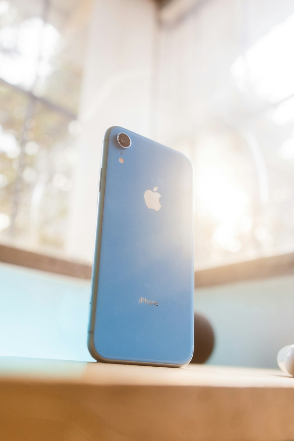 나무 테이블 위에 앉아 있는 파란색 아이폰