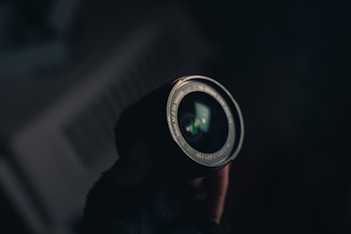 a person holding a camera lens in their hand
