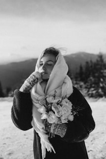 a woman is standing in the snow with a scarf around her neck