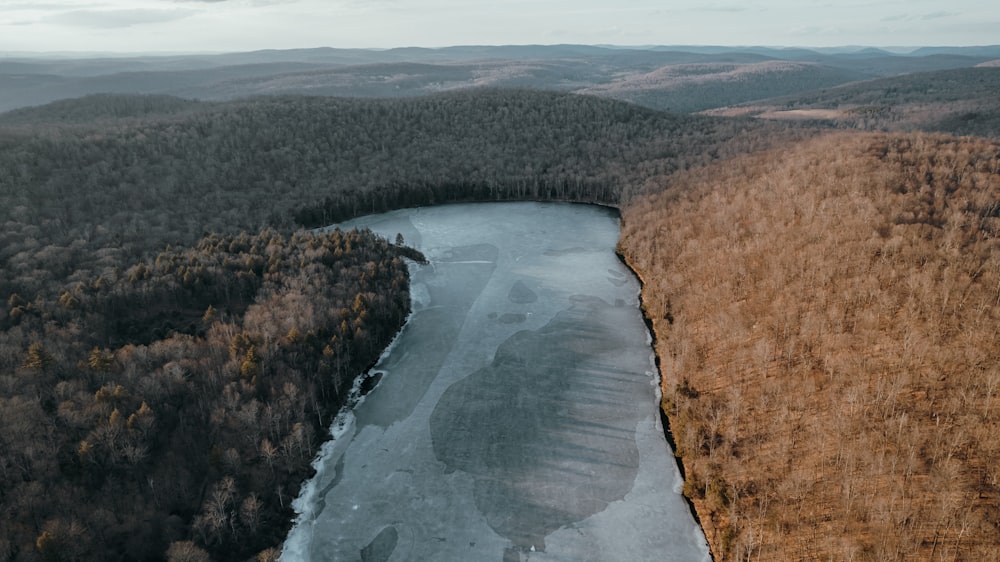 an aerial view of a river surrounded by trees