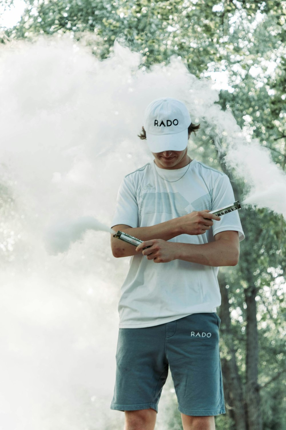 a man standing in front of a cloud of smoke holding a cell phone