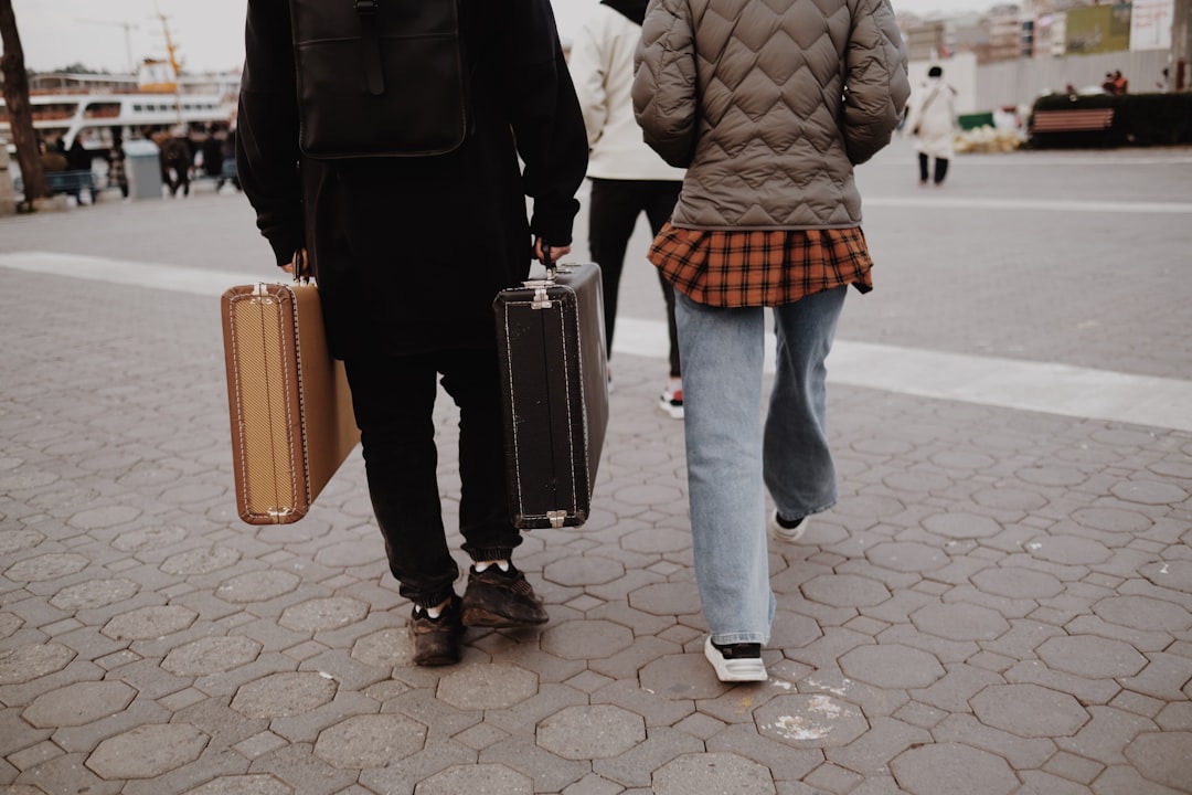 a man and a woman walking down a street with luggage,