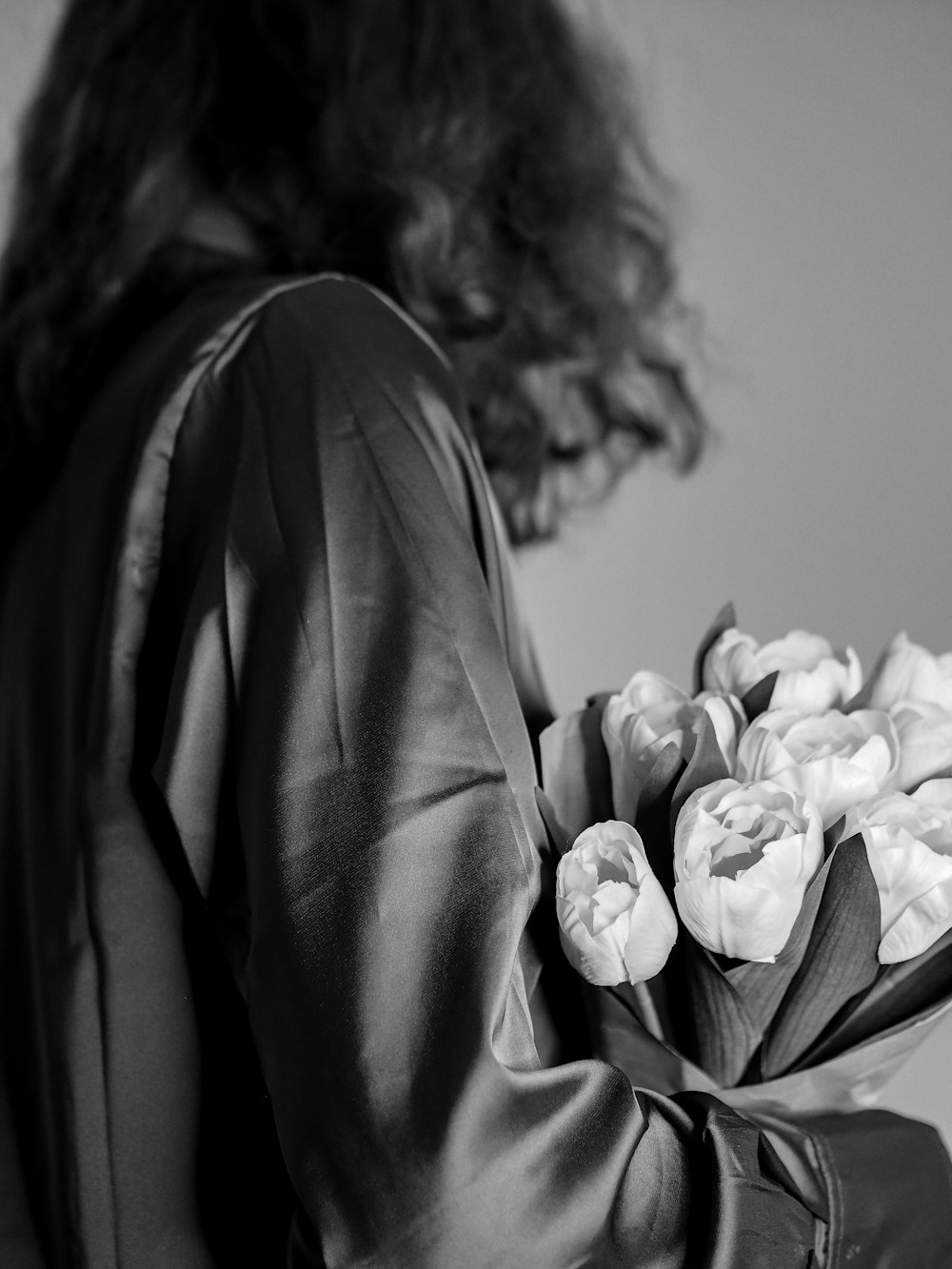 a black and white photo of a woman holding a bouquet of flowers