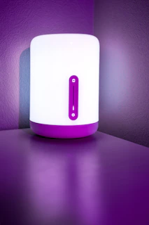 Modern 3D printed lamp casting soft purple light in a cozy room corner.