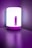 A modern, cylindrical lamp with a smooth surface and soft white light sits on a purple table. The body of the lamp features a prominent purple accent with a power button and a control slider. The purple wall and table create a harmonious and stylish atmosphere.
