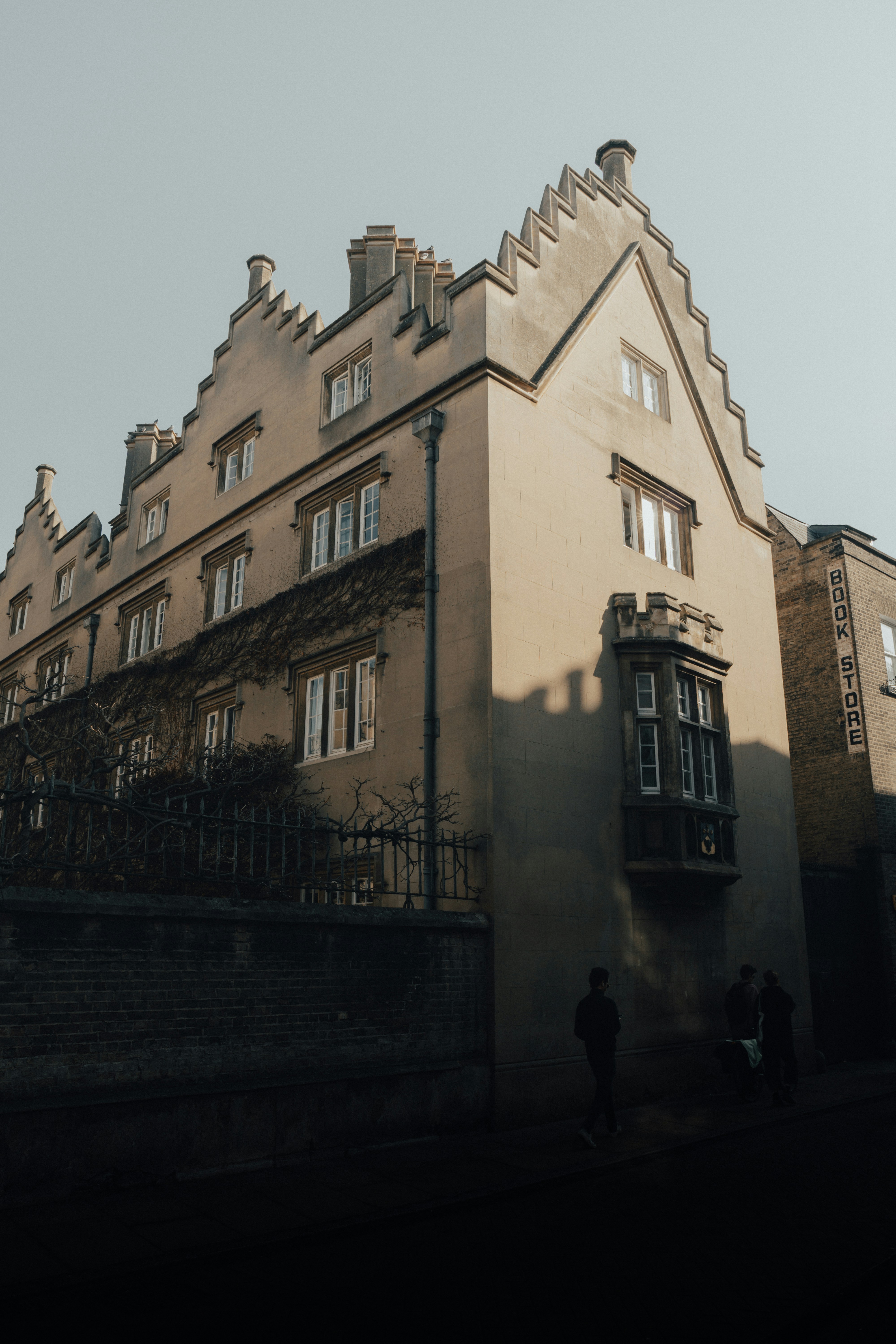 Un edificio alto con molte finestre accanto a una recinzione