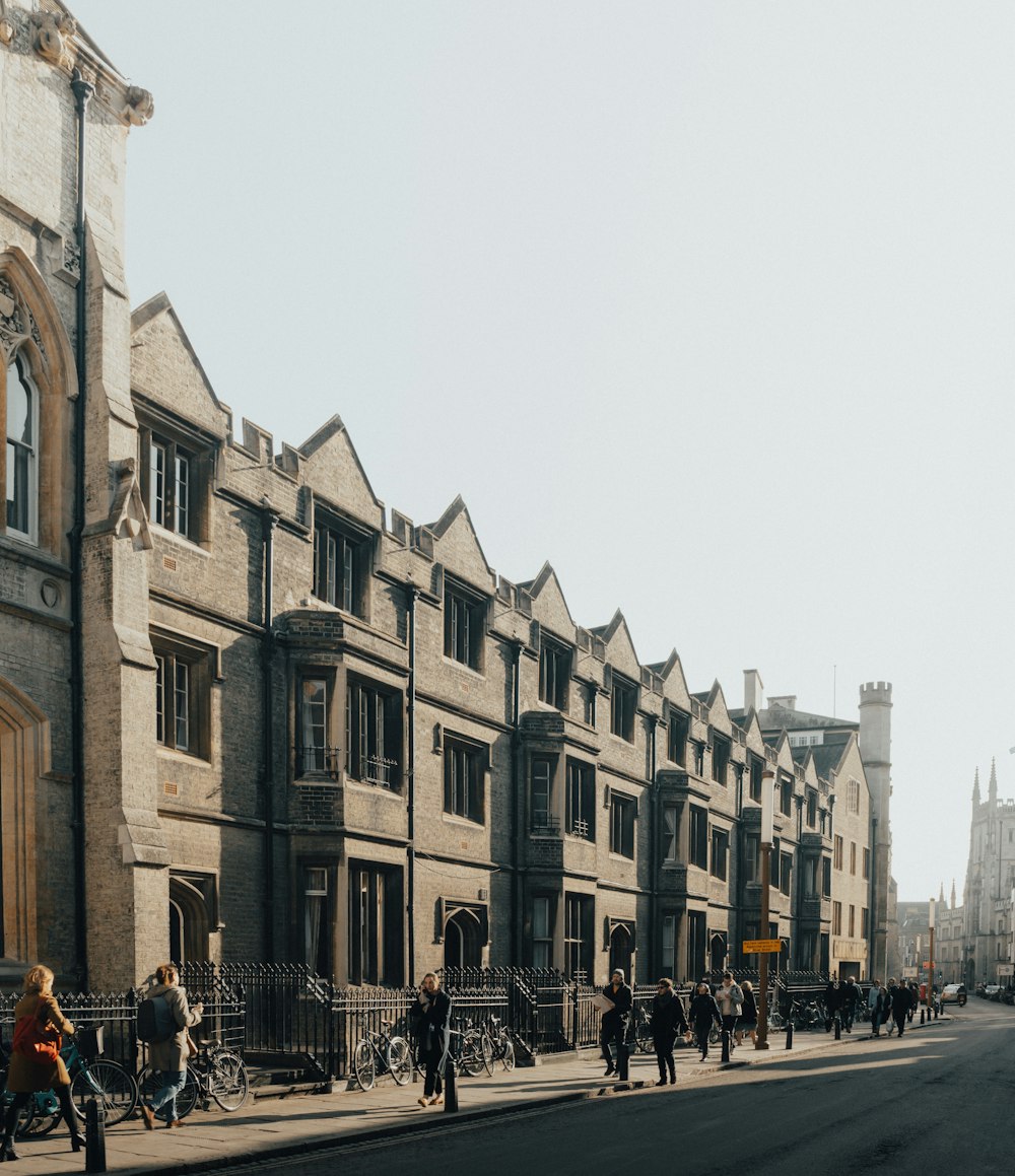 a group of people walking down a street next to tall buildings