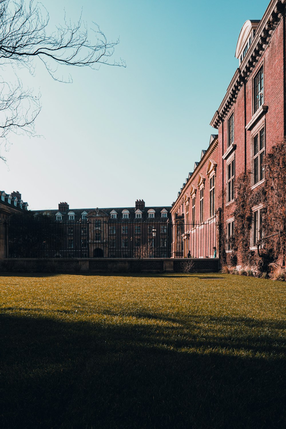 a grassy field in front of a large brick building