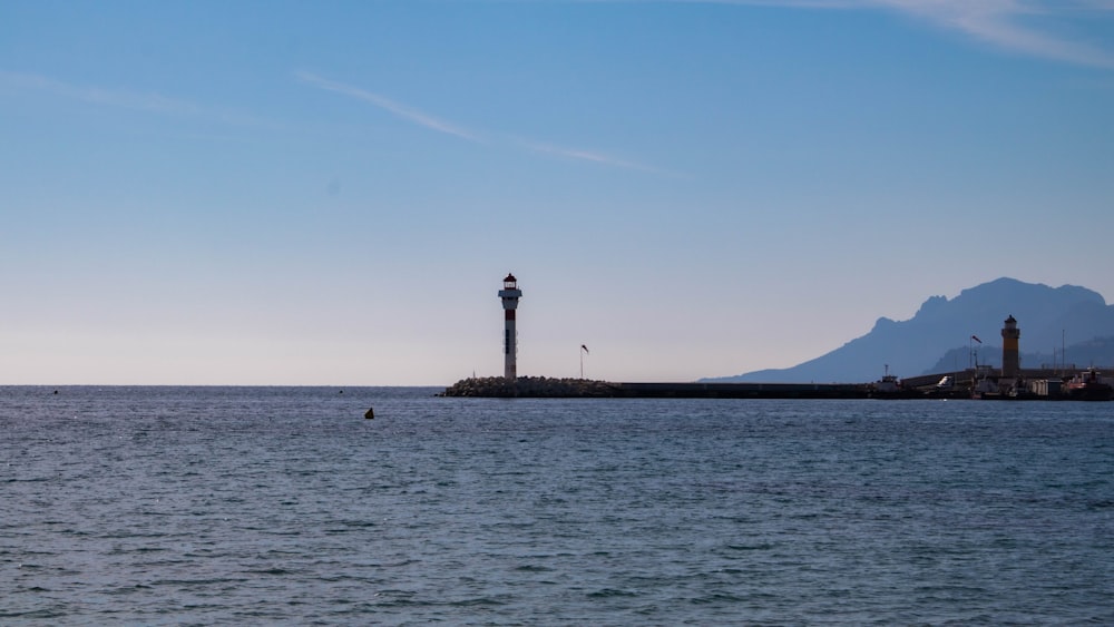 a large body of water with a light house in the distance