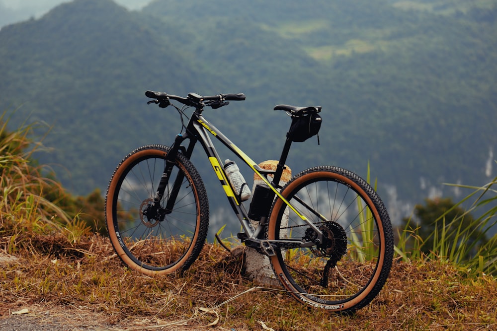 a bicycle parked on top of a grass covered hillside