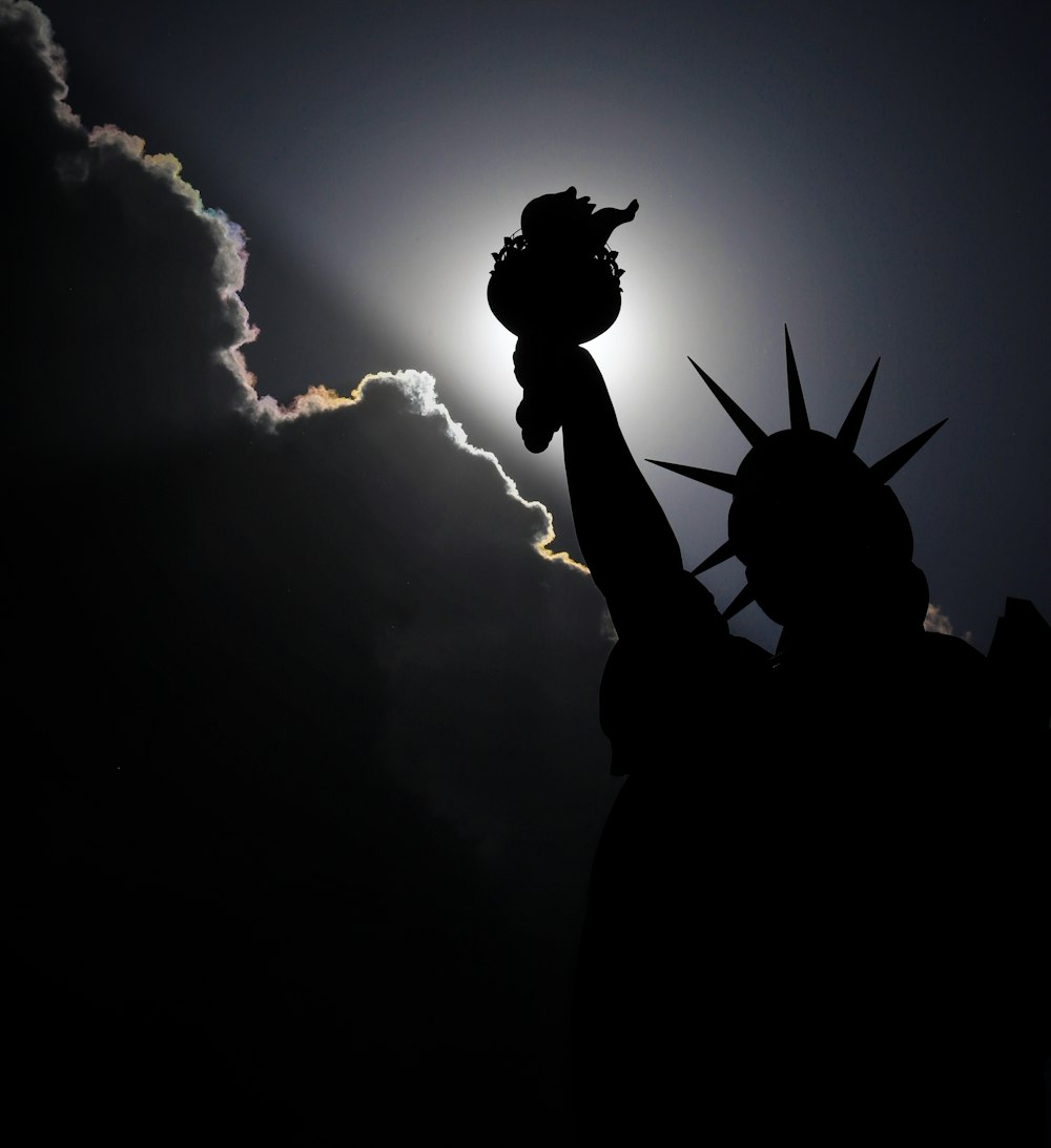 the statue of liberty is silhouetted against the sun