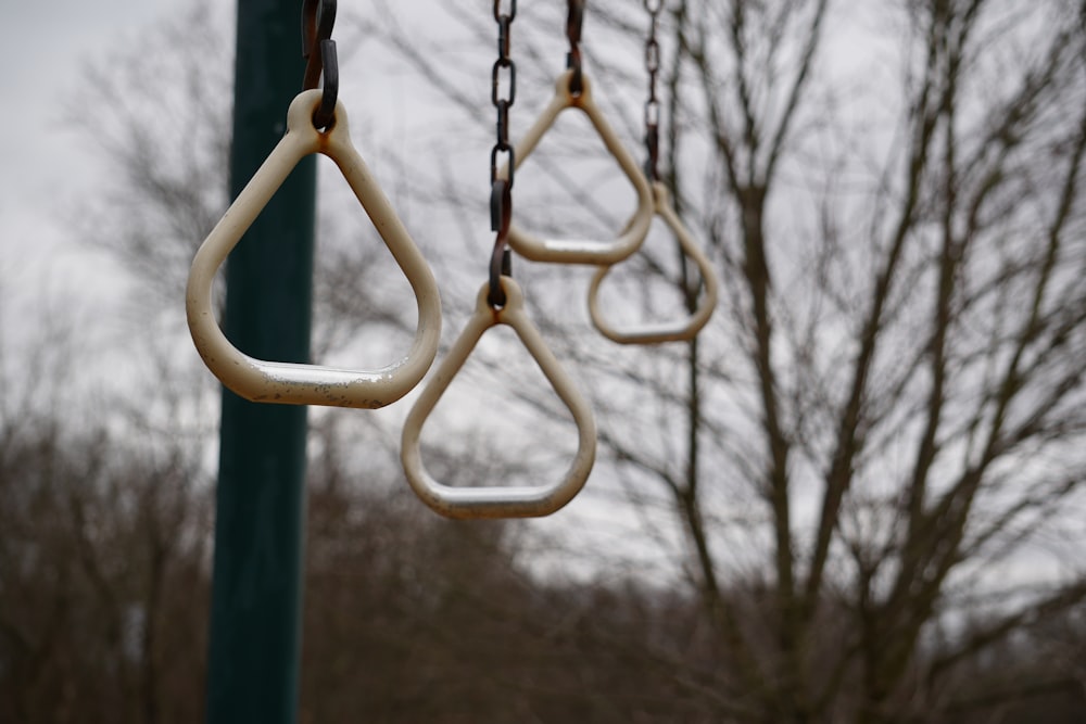 a group of swings hanging from a green pole
