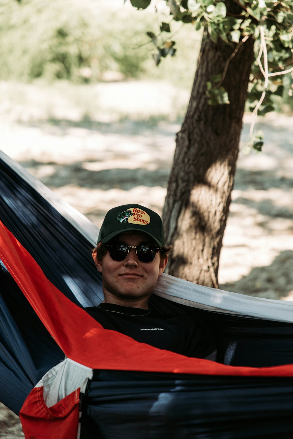 a man laying in a hammock in the shade