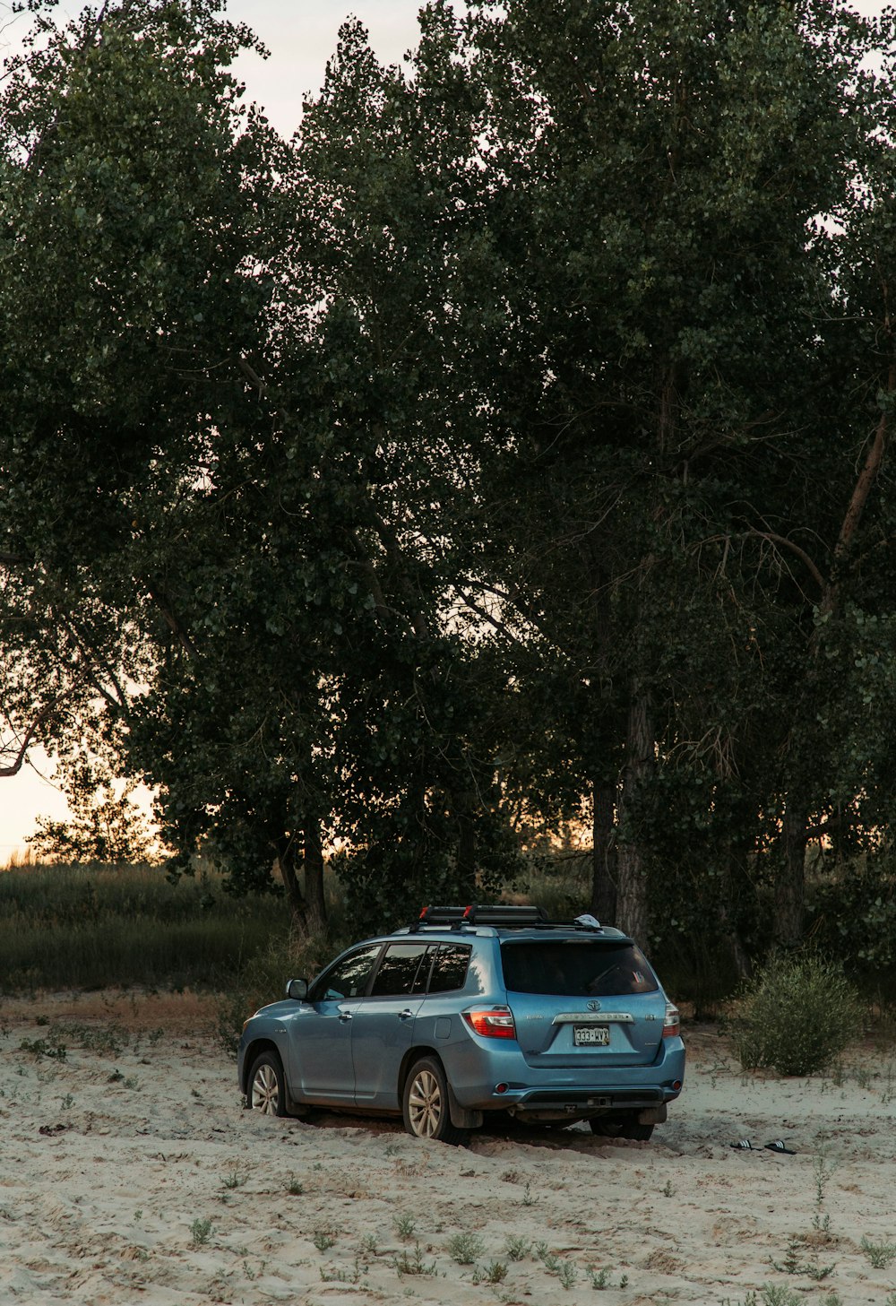 a blue car parked in the middle of a field