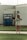 A person wearing a Colorado t-shirt and talking on the phone stands in front of a building with a sign reading 'Banner Strong salutes our Healthcare Heroes'. The building is made of light-colored bricks and the person appears happy.