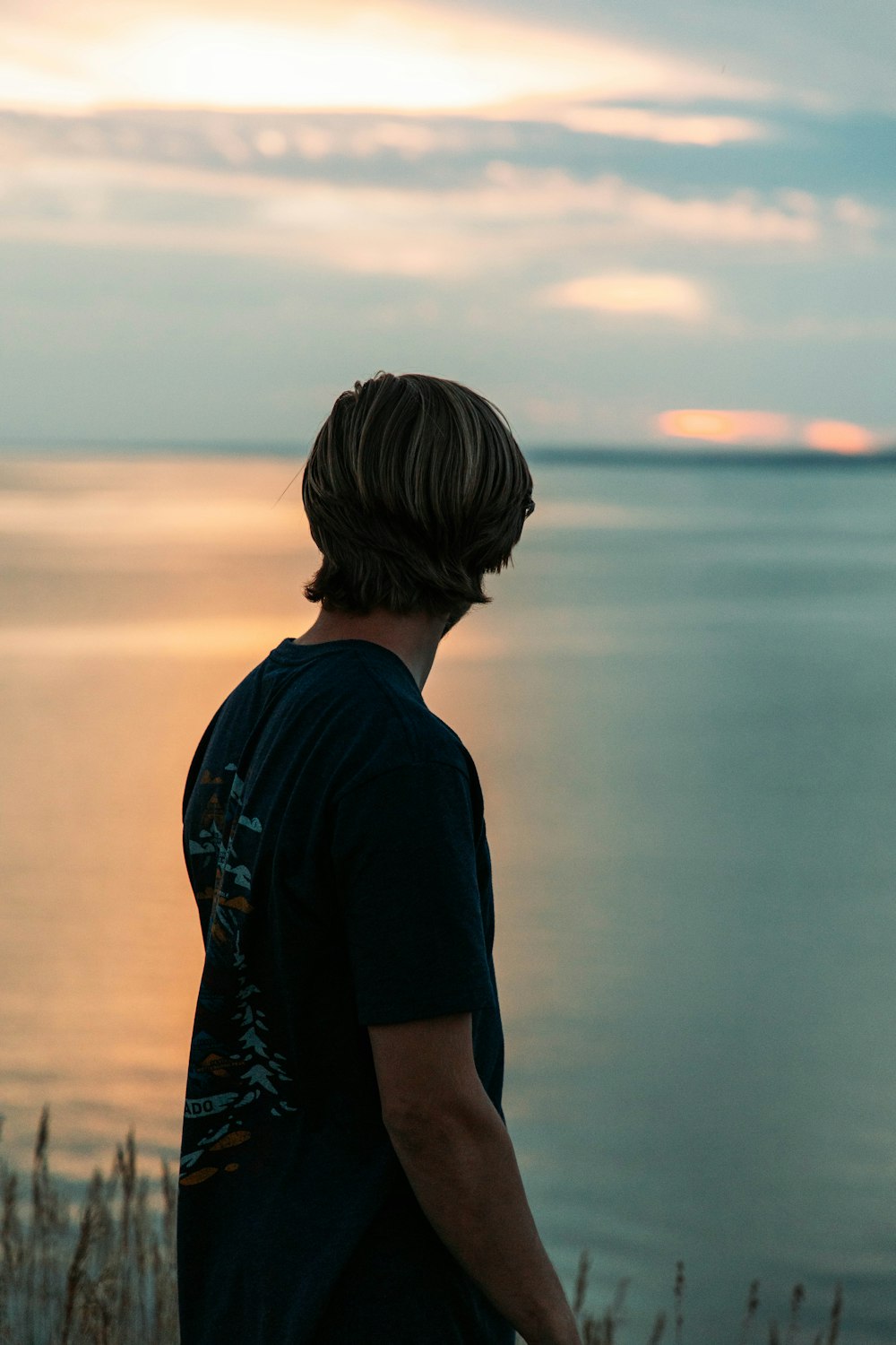 a man standing in front of a body of water