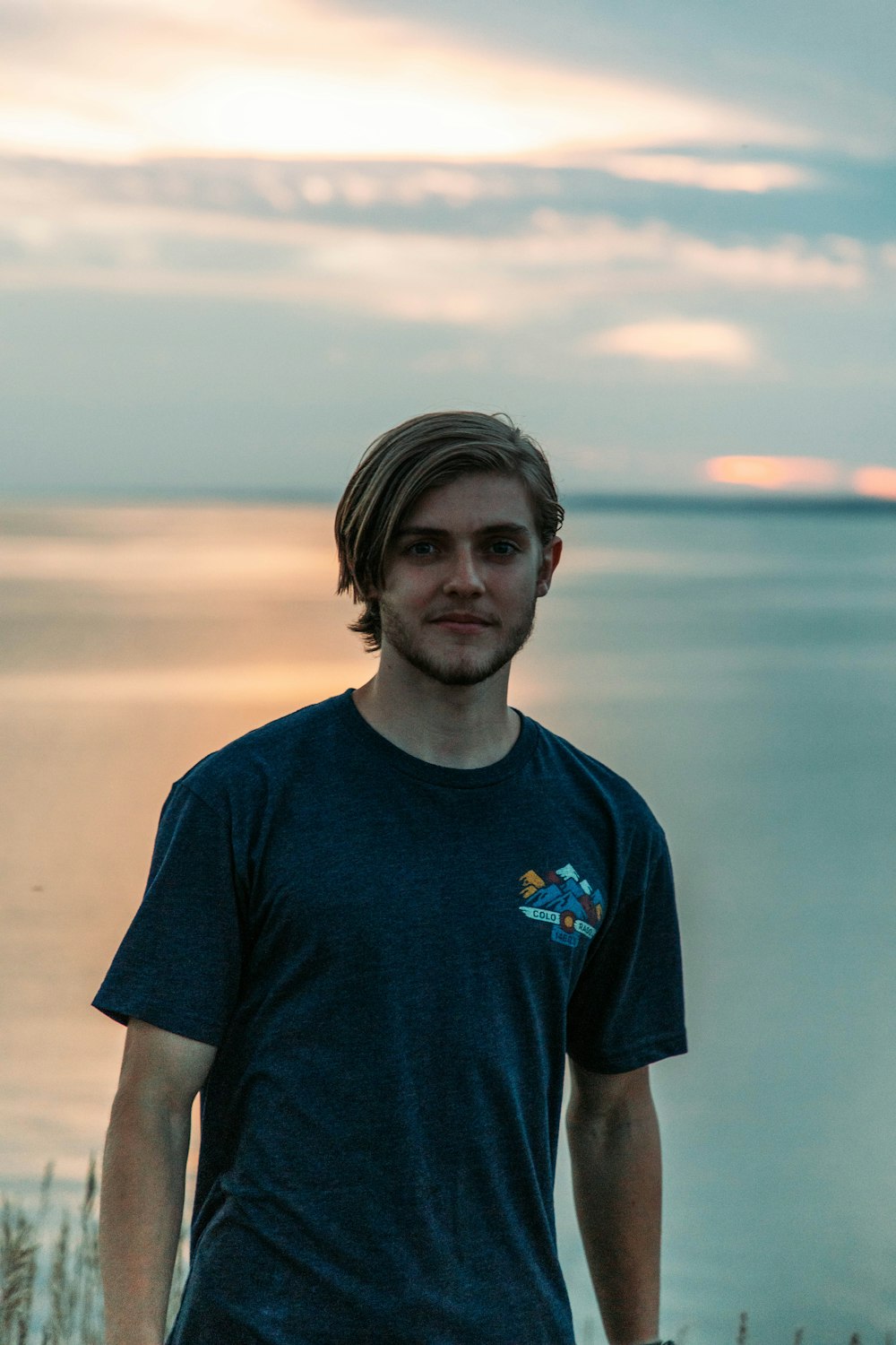 a man standing in front of a body of water