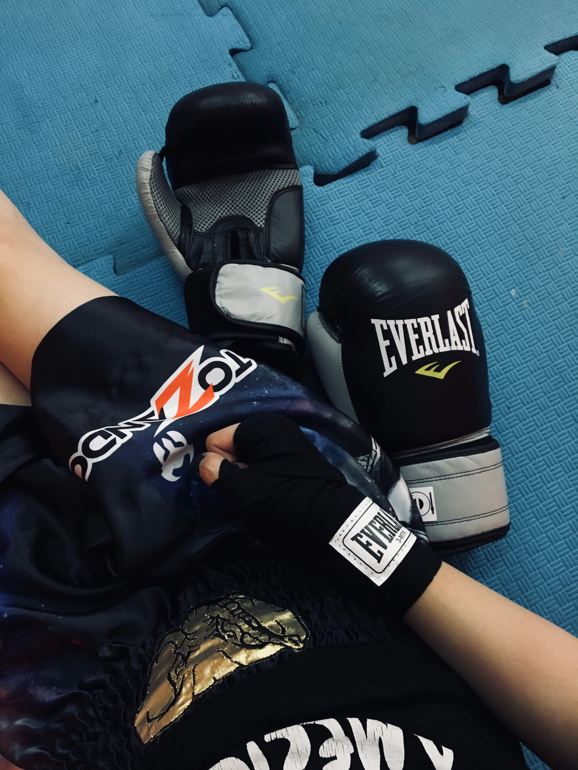 a pair of boxing gloves laying on top of a blue floor