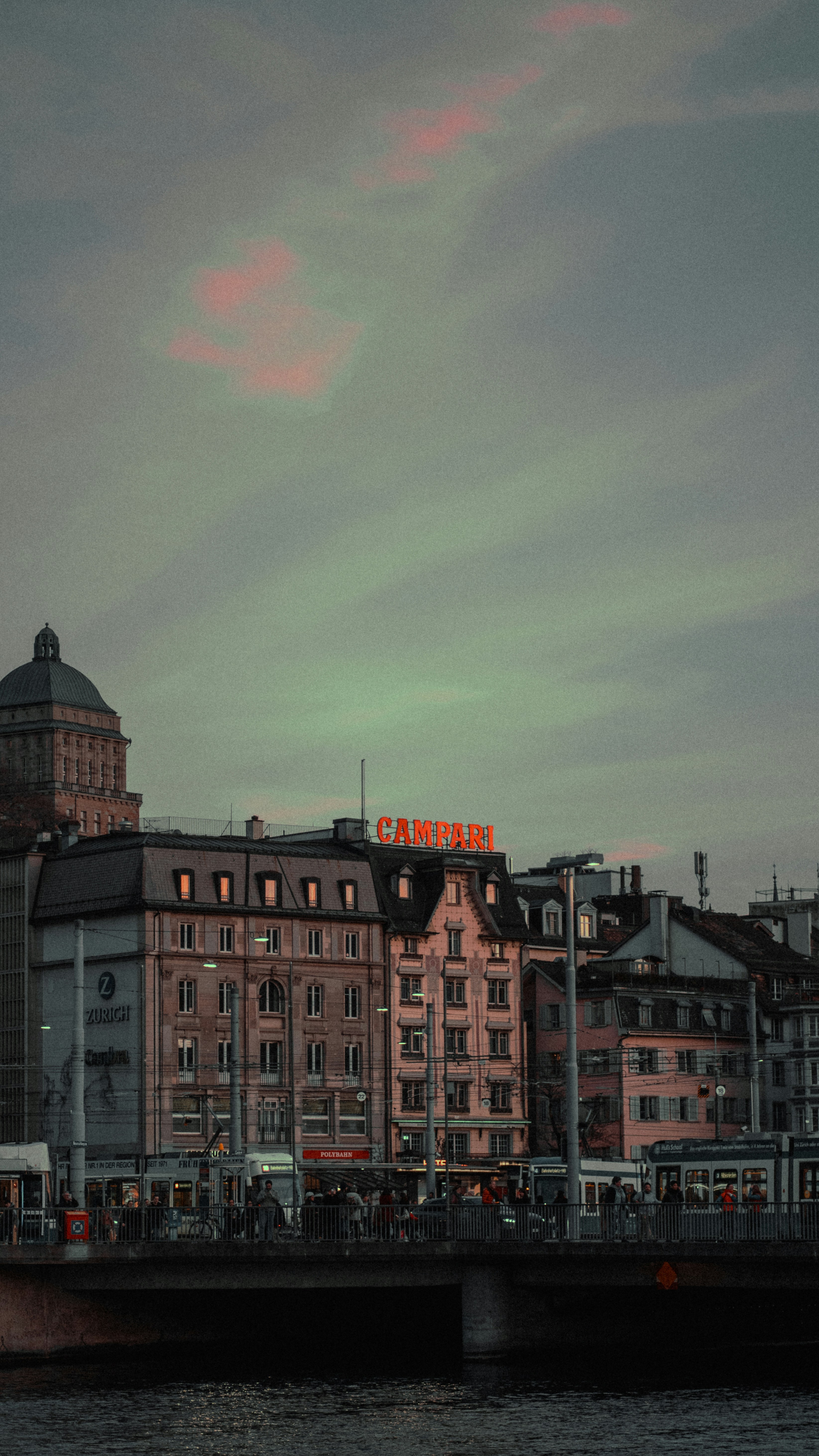 a large building sitting on top of a river next to a bridge