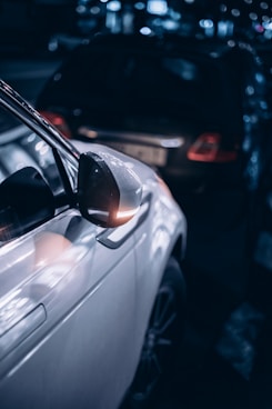 a white car parked in a parking lot next to another car