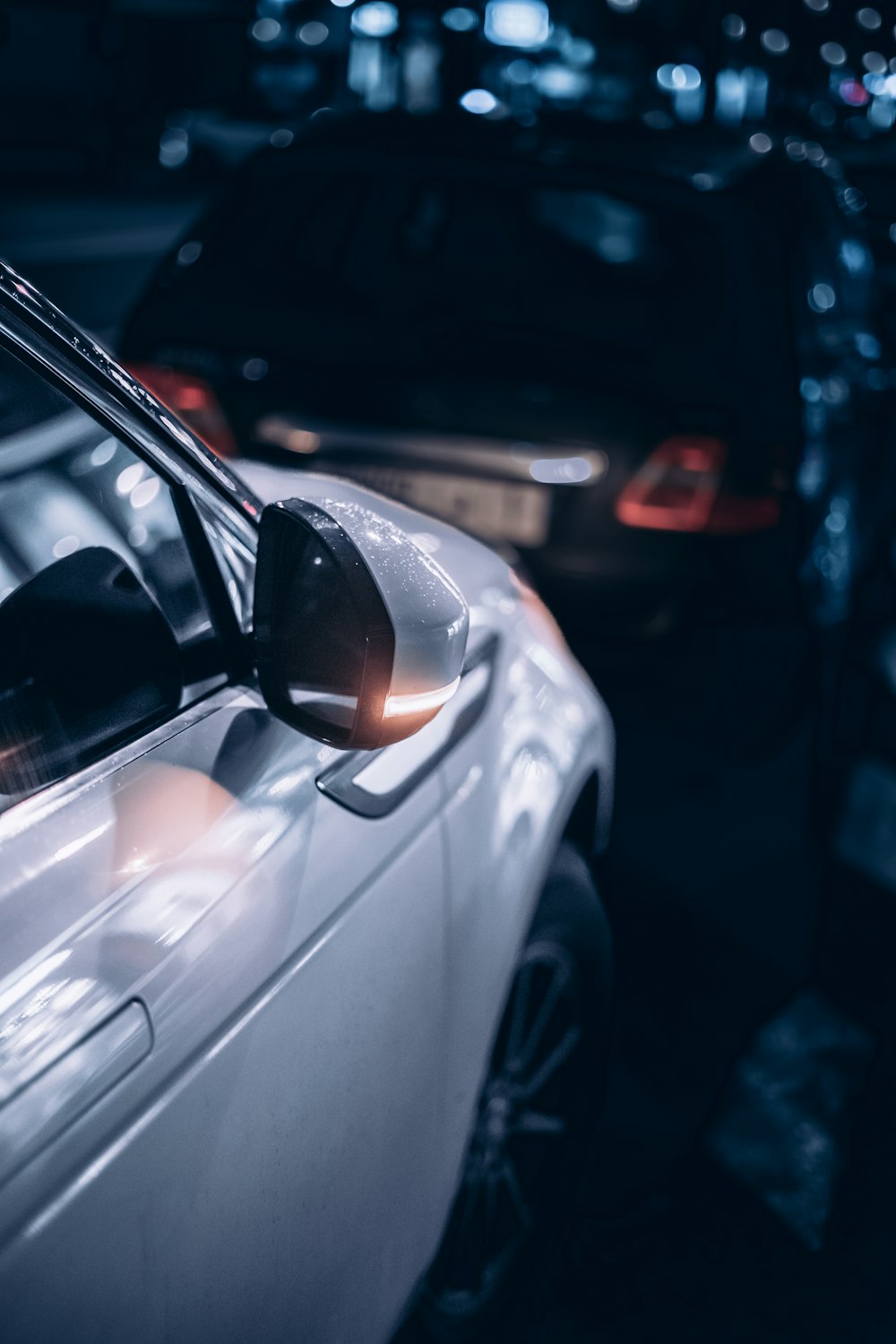 a white car parked in a parking lot next to another car