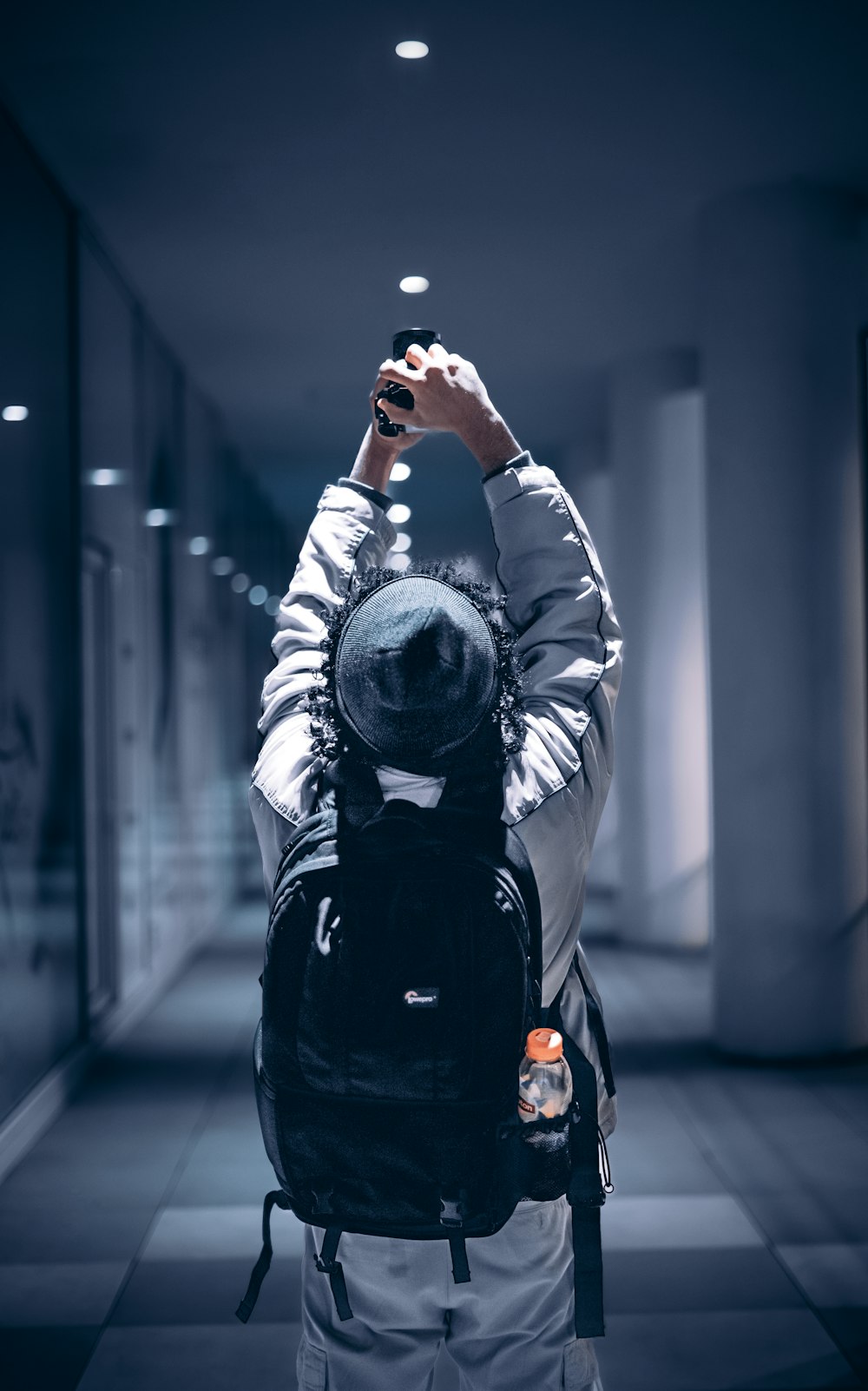 a person with a backpack taking a picture with a cell phone