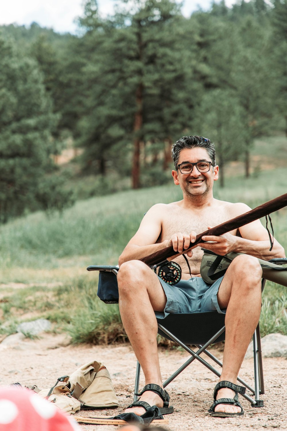 a man sitting in a camping chair with a rifle