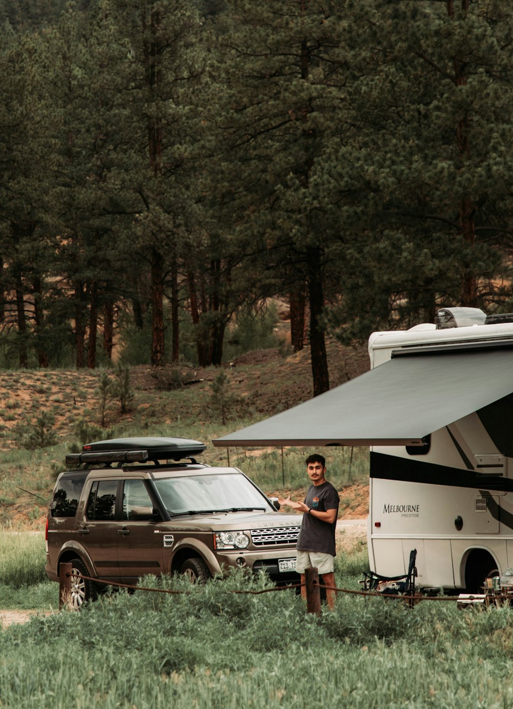 a man standing next to a parked camper