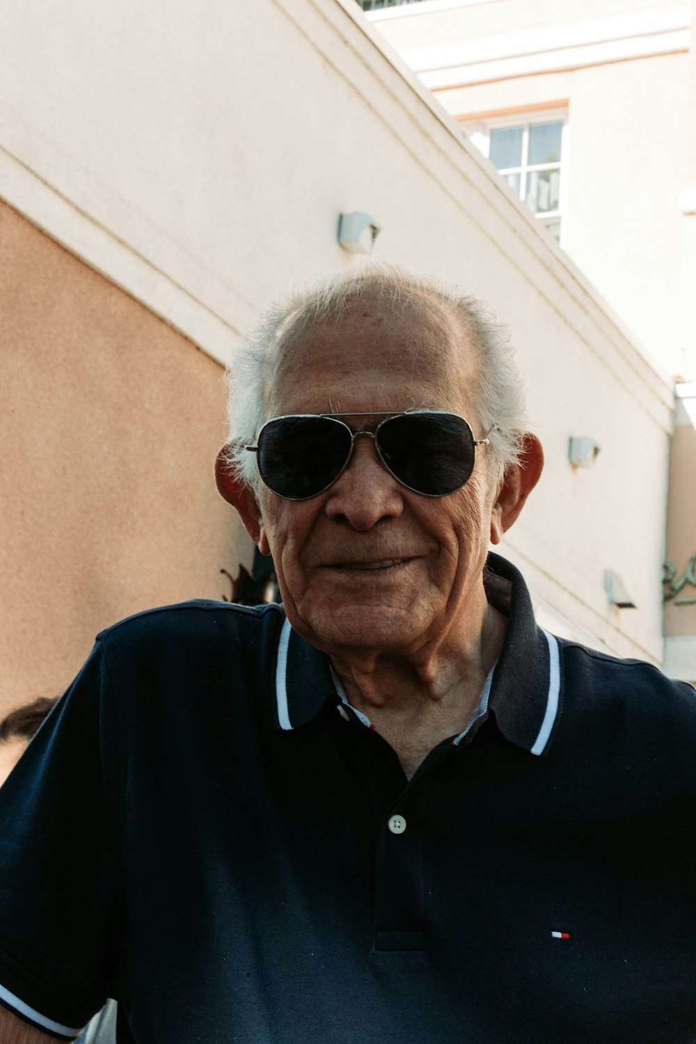 Un uomo anziano che indossa occhiali da sole e una polo