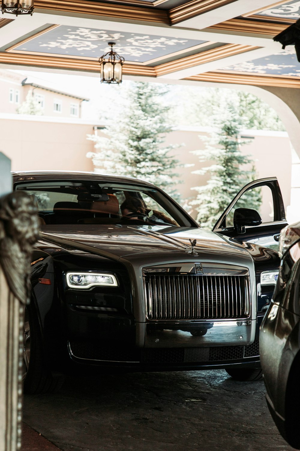 a black rolls royce parked in a garage