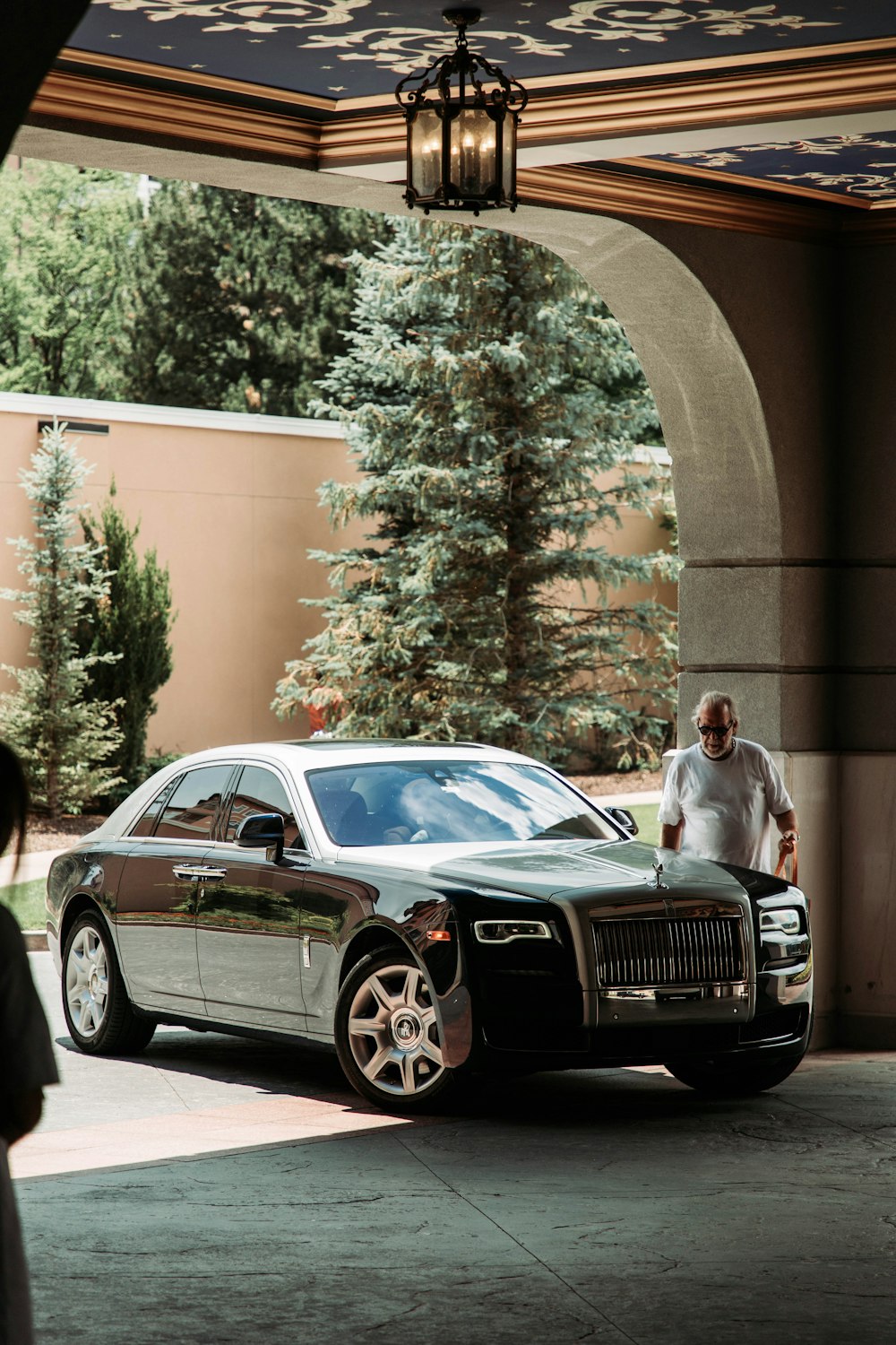 a man standing next to a car in a driveway